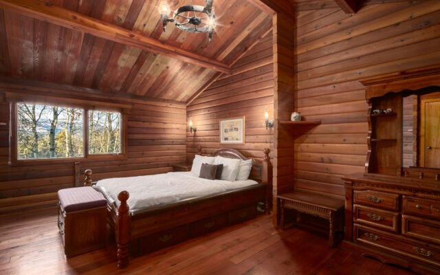Quaint wood cabin surrounded by greenery and trees.