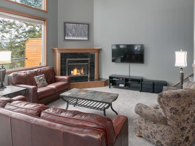 Living room area with two red leather couch, chair, coffee table, and television